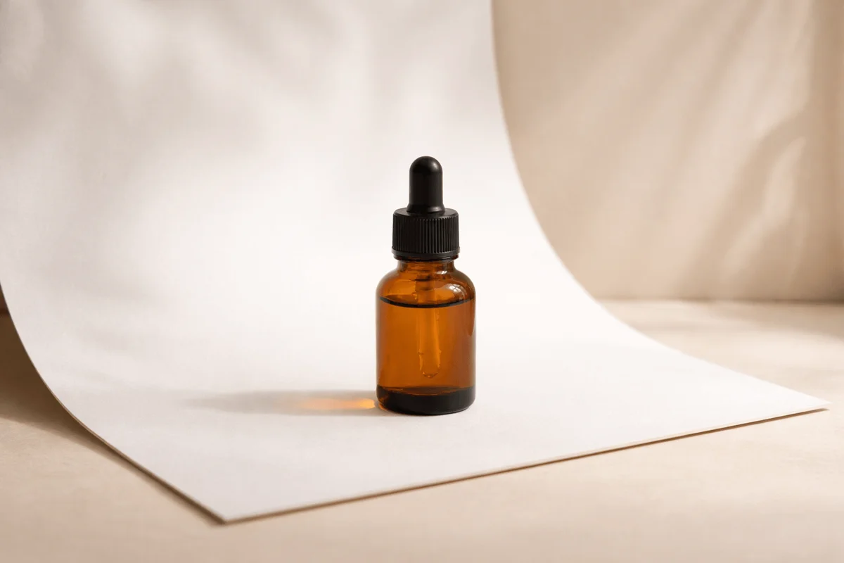A clean product photo of a skincare bottle on a marble surface with soft natural light